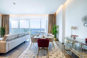 sala de estar con sofá y mesa en Private Beach - 4BR - 8 Sleep - Pool - 180 grades Sea & Ain View - Huge Balcony - Parking - Prime Location, en Dubái