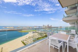 balcón con mesa y sillas y playa en Private Beach - 4BR - 8 Sleep - Pool - 180 grades Sea & Ain View - Huge Balcony - Parking - Prime Location, en Dubái