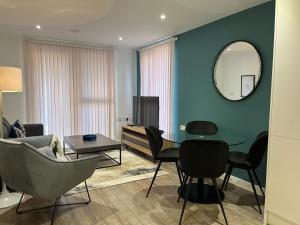 a living room with a table and chairs and a mirror at Southampton City Apartments by Charles Hope in Southampton