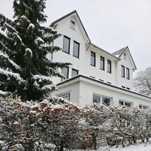uma casa branca com neve no chão em Ferienwohnung Faber em Goslar