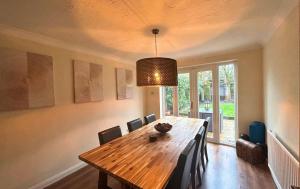 a dining room with a wooden table and chairs at Binfield - Spacious Luxurious Four Bedroom House in Bracknell