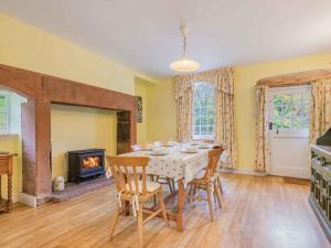 a dining room with a table and chairs and a fireplace at 3 Bed in Lazonby SZ198 in Kirkoswald