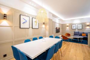 a meeting room with a white table and blue chairs at 191 Suite Auteuil - Superb apartment in Paris in Paris