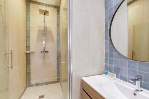 a bathroom with a shower and a sink and a mirror at 191 Suite Auteuil - Superb apartment in Paris in Paris