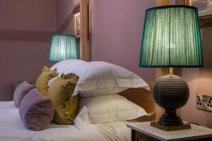 1 dormitorio con 1 cama con almohadas y 2 lámparas en East Beach Guest House en Littlehampton