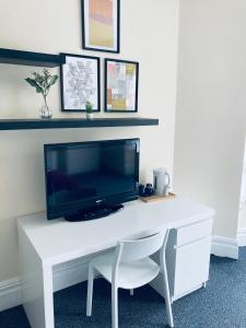 a white desk with a tv on top of it at Abbeyfield Guesthouse in Liverpool