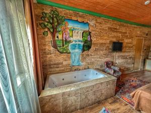 a bath tub in a room with a painting on the wall at ARTON İN CAPPADOCİA HOTEL in Avanos