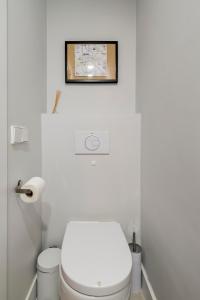 baño con aseo y una foto en la pared en Charming Malasaña Vibes - Alquileres Temporales, en Madrid