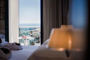 a hotel room with a bed and a view of a table at Hotel Villa Rosa Riviera in Rimini