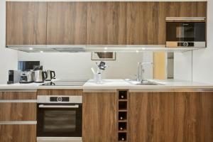 uma cozinha com armários de madeira e um lavatório em 270 Suite Haute - Superb apartment in Paris. em Paris