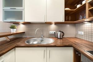 a kitchen with white cabinets and a sink at Apartment with cozy balcony by URBAN RENT in Kaunas