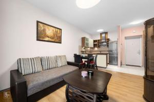 a living room with a couch and a table at Apartment with cozy balcony by URBAN RENT in Kaunas