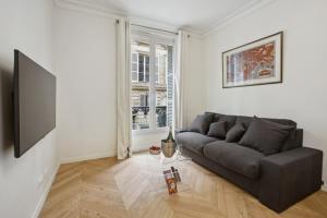 uma sala de estar com um sofá e uma televisão em 270 Suite Haute - Superb apartment in Paris. em Paris
