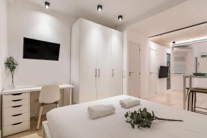 Habitación blanca con cama y escritorio en Charming Malasaña Vibes - Alquileres Temporales, en Madrid