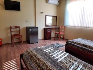 a hotel room with two beds and a desk and a mirror at Motel Elegance in Sandanski