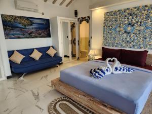 1 dormitorio con 1 cama grande y 1 sofá en The Kayu Manis Villa, en Lovina