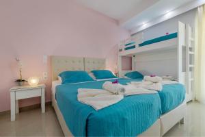 een slaapkamer met 2 bedden, handdoeken en een stapelbed bij Palotel Design Gouvia in Gouvia