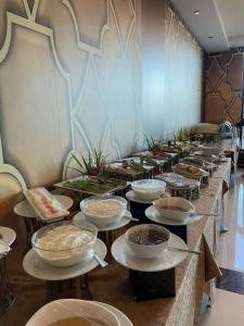 a buffet line with plates and bowls of food at Villa Park in Al Khobar