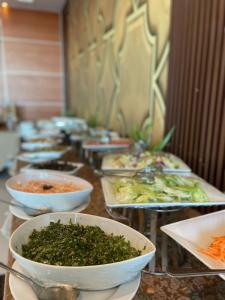 une rangée de bols remplis de légumes sur une table dans l'établissement Villa Park, à Khobar
