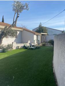 a yard with two picnic tables and a building at Villa ou studio indépendant PISCINE sans vis à vis in Mudaison