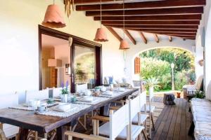 a dining room with a long table and chairs at Authentic 4BR Pool & Sauna Villa, Sant Agusti in San Antonio Bay