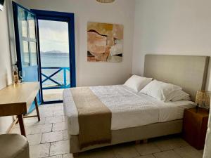 sypialnia z łóżkiem i widokiem na ocean w obiekcie Agia Fotia Taverna w mieście Kerames