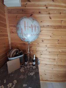 a balloon with a happy anniversary written on it on a table at The Hut B & B in Mochdre