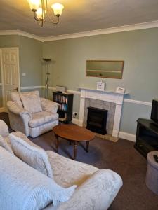 a living room with a couch and a fireplace at Elysian Fields @ Ing Hill Lodge in Outhgill