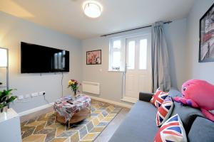 salon z niebieską kanapą i misiem w obiekcie 2 BED TERRACED FLAT PICCADILLY LINE w Londynie