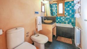a bathroom with a toilet and a sink and a tub at Casas Rurales Camino del Castaño in Galaroza