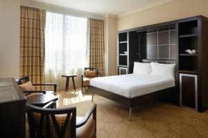 ミルウォーキーにあるMilwaukee Marriott Downtownのベッドとデスクが備わるホテルルームです。