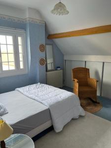 - une chambre avec un grand lit et une chaise dans l'établissement Villa damobricero, à Allonnes