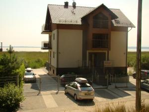 una casa con dos coches aparcados en un estacionamiento en Villa Piaski, en Krynica Morska