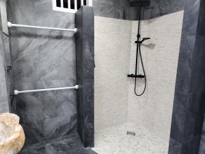 a shower with a glass door and a shower at The Kayu Manis Villa in Lovina