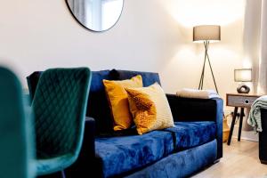 a blue couch with yellow pillows in a living room at Cartside House in Johnstone