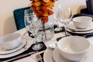 een tafel met borden en wijnglazen erop bij Cartside House in Johnstone