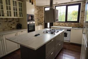 uma cozinha com armários brancos e um forno com placa de fogão em Mas del Cel - Casa Rural em Confrides