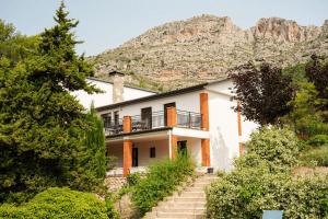 a house with a mountain in the background at Mas del Cel - Casa Rural in Confrides