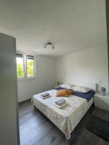 ein Schlafzimmer mit einem Bett und zwei Fenstern in der Unterkunft Beachfront Holiday House Melissa in Vinišće