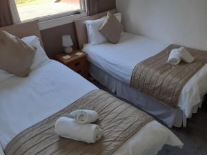 two beds in a hotel room with towels on them at Island view in Spittal