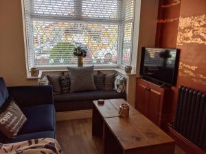 a living room with a couch and a tv at Unique and Stylish close to Beaches Restaurants Shops in Cleethorpes