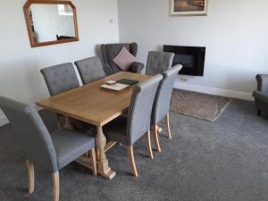 a dining room table with chairs and a mirror at Island view in Spittal