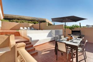 a patio with a table and chairs and an umbrella at Los Corcos Rural Farm With Private Pool in Playa de San Juan