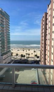 uma vista para a praia a partir de uma varanda de um edifício em Apartamento vista mar na Praia Grande