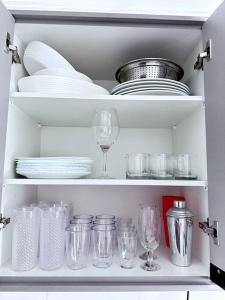 a cabinet filled with dishes and glasses and plates at Apartamento vista mar in Praia Grande