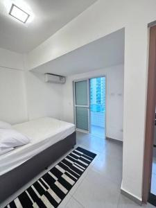 um quarto com uma cama e um tapete preto e branco em Apartamento vista mar na Praia Grande