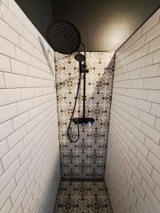 a shower in a bathroom with white tiles at Pension am Bahnhof Kavelstorf in Kavelstorf