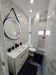ein weißes Badezimmer mit einem Waschbecken und einem Spiegel in der Unterkunft Le Coeur de Cahor! 2 bedroom luxury rental 85m2. in Cahors