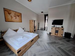 a bedroom with a bed and a flat screen tv at Pension am Bahnhof Kavelstorf in Kavelstorf
