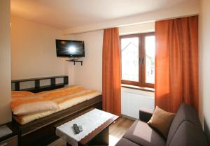 a hotel room with a bed and a tv at Villa Piaski in Krynica Morska